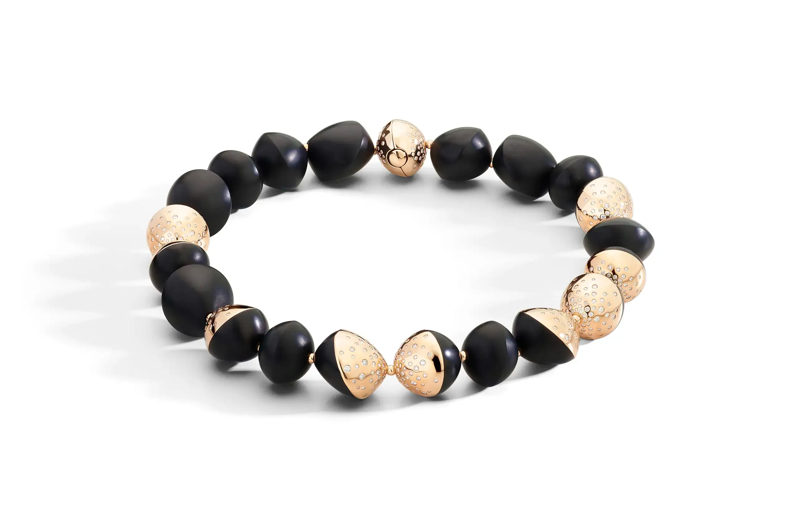 Trottola bracelets and necklaces alternate rose gold and black jet in a continuous rhythm, with concealed clasps preserving the purity of the composition.