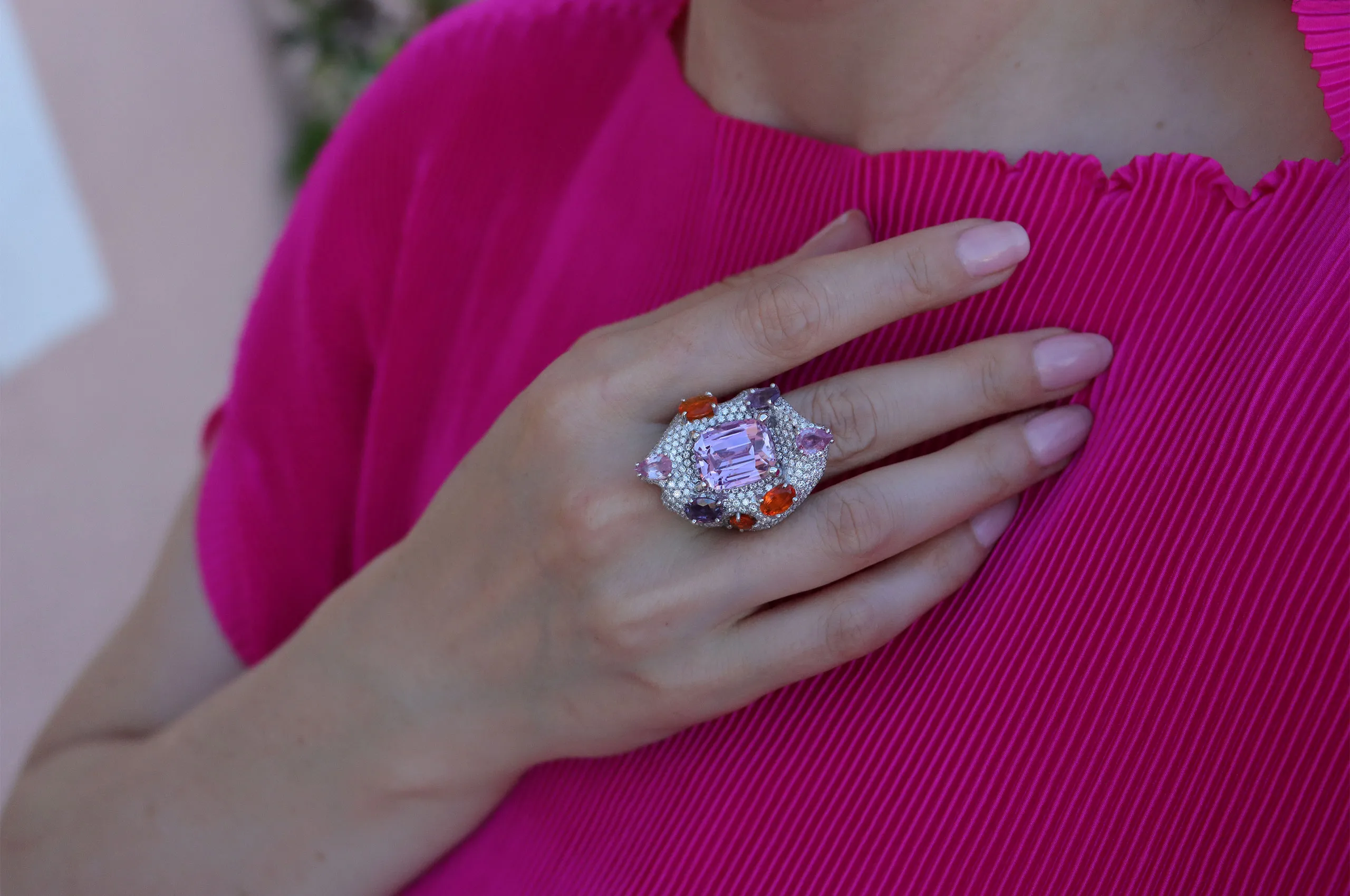 The kunzite is surrounded by pink and orange sapphires, on a bed of pavé white diamonds
