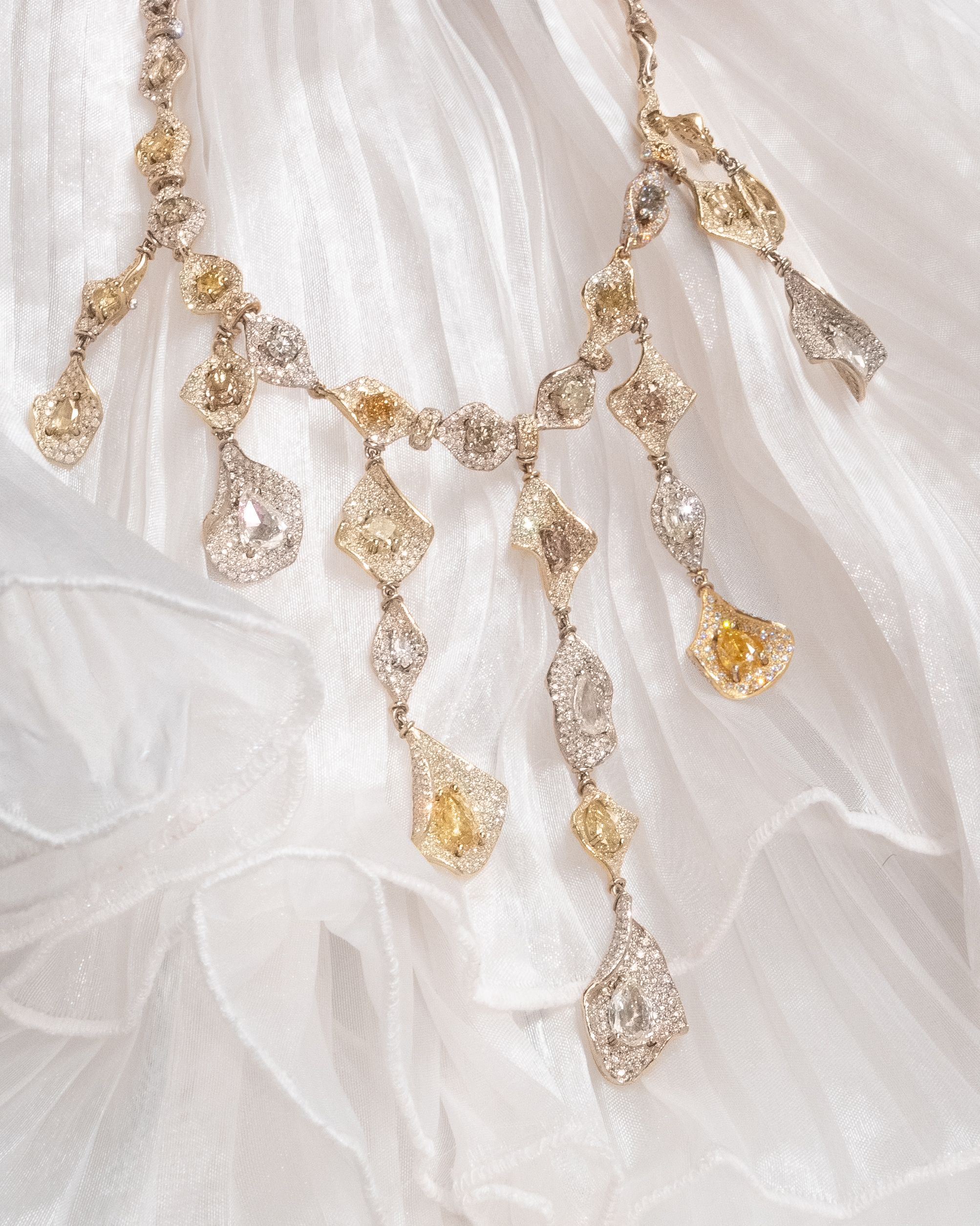 Maison d'Avossa necklace made up of white and yellow gold elements and fancy diamonds in various natural shades, enclosed in pavé white diamond leaves