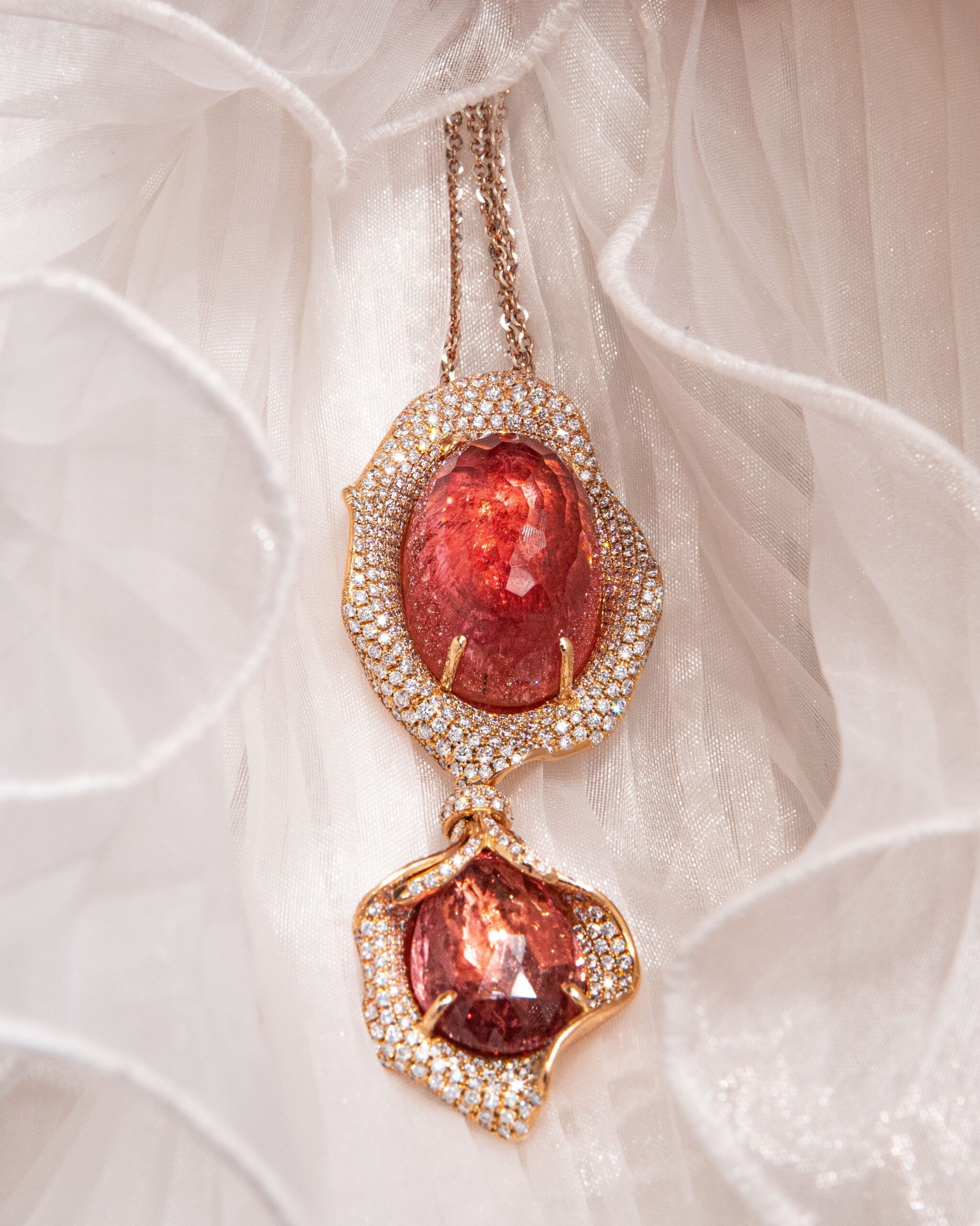 A rose gold and white diamond d'Avossa pendant holds a stunning pink tourmaline at its heart, made even more luminous by its briolette cut. Another tourmaline in a slightly darker shade adds movement