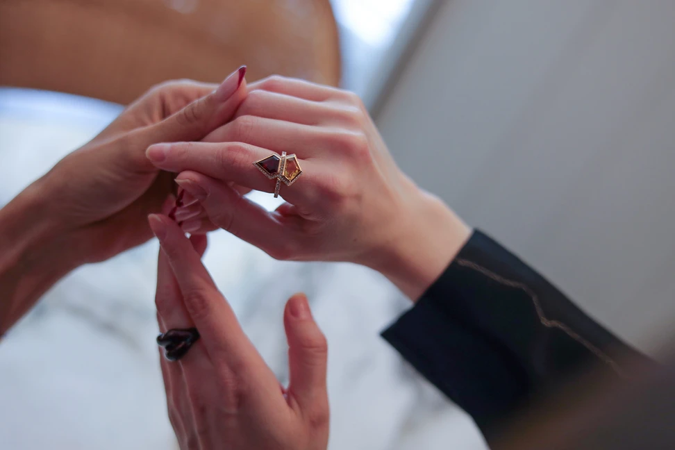<p>Katerina Perez shows Farnoush Hamidian her bespoke Superwoman ring created by German jeweller, Sabine Roemer</p>