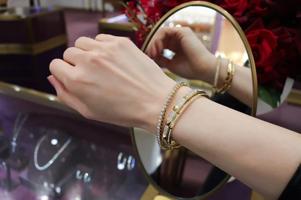 A stack of ANTON R.08® bracelets: the 6.56ct Matrix diamond tennis bracelet with the Une and Deux diamond stud motif bangles in 18k yellow gold