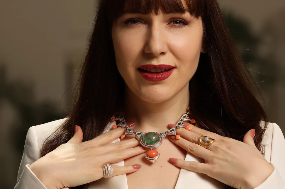 A closer look at Bachtale’s Bahia necklace, combining a cabochon emerald, coral, emeralds and diamonds, worn with a selection of the Maison’s rings