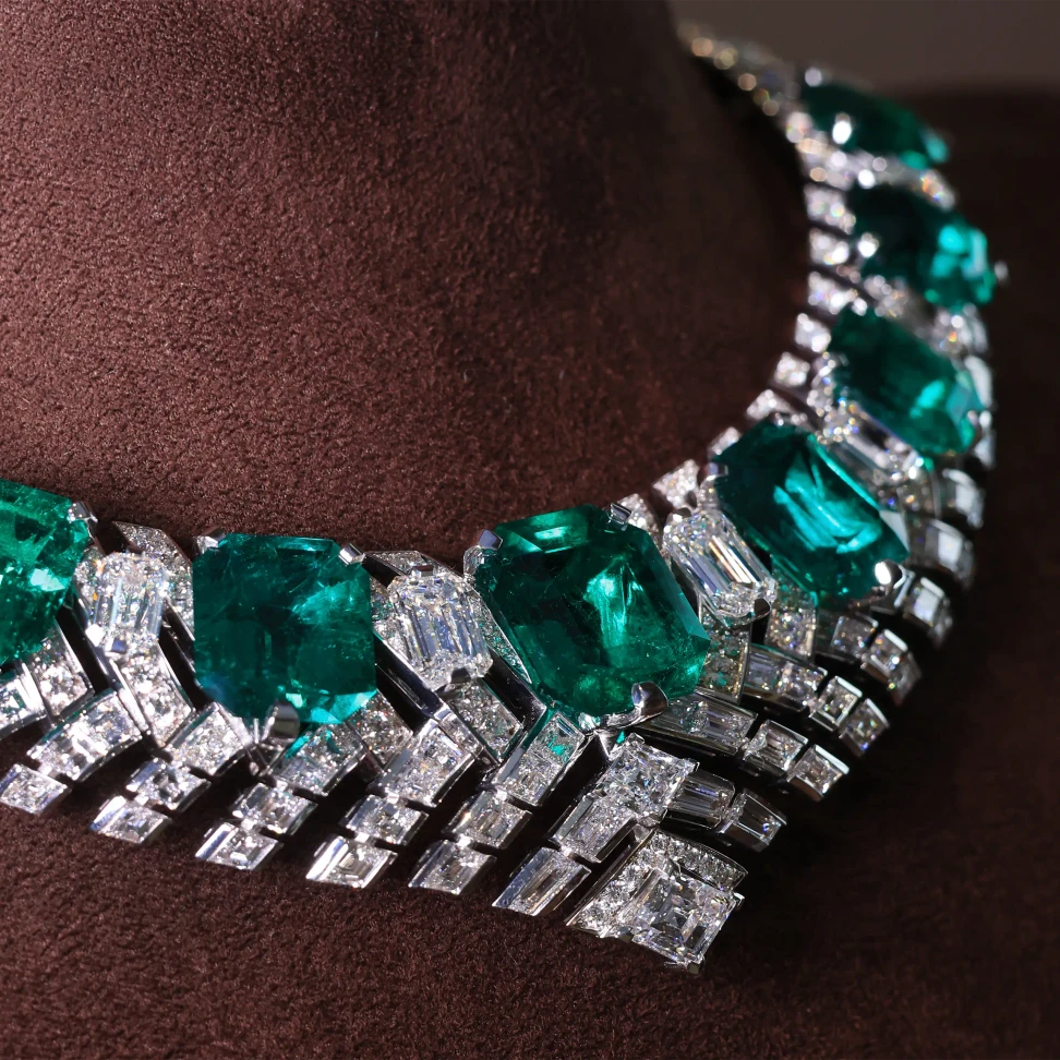 A closer look at the Kalamos necklace, where geometric rows of diamonds frame the Colombian emeralds