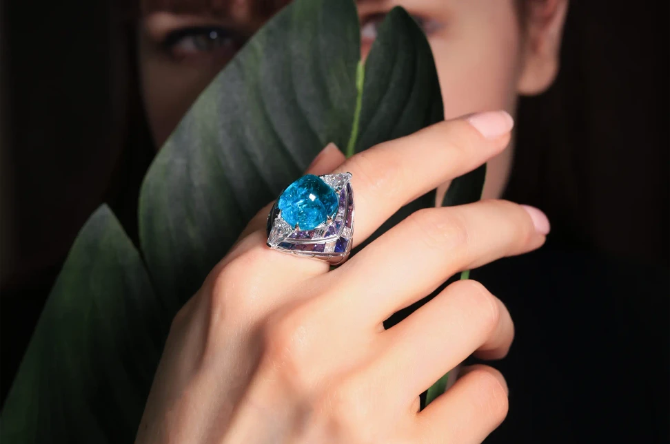 Katerina Perez wears the Tetra ring, contrasting a smooth 12.95-carat Brazilian Paraiba tourmaline cabochon with geometric lines of sapphires and diamonds