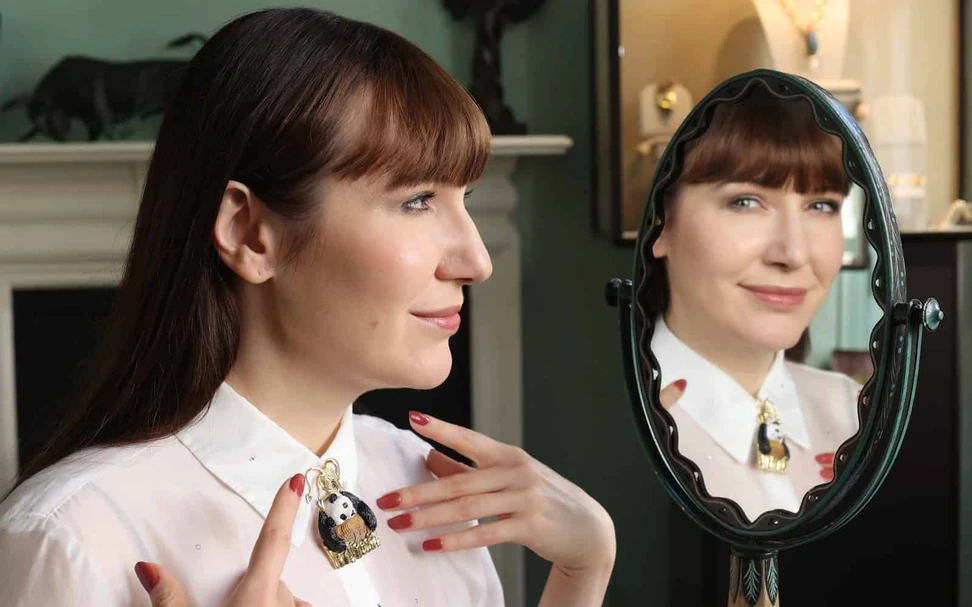 <p>Katerina Perez wears the “Sleeping Beauty” pin by Elizabeth Gage depicting a panda in cacholong, onyx and rock crystal (104.39 carats) and carved petrified wood in 18k gold</p>