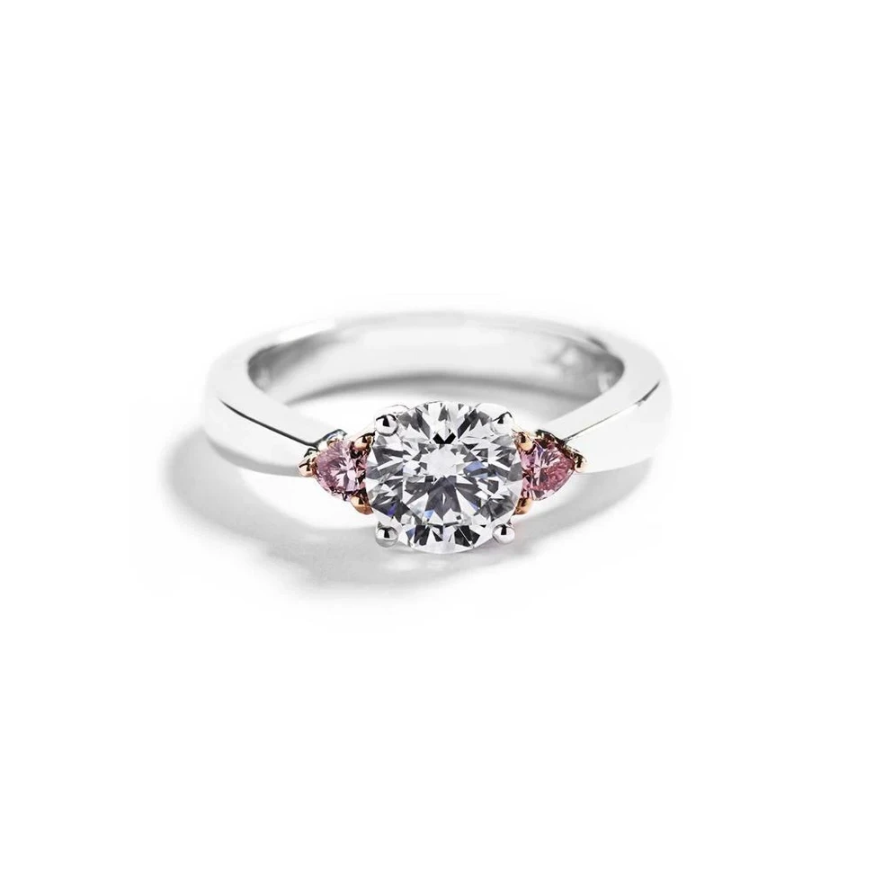 <p>Hartmann Copenhagen Heart 3-stensring med 1,25 ct diamant og 0,18 ct. Argyle Pink diamanthjerter</p>