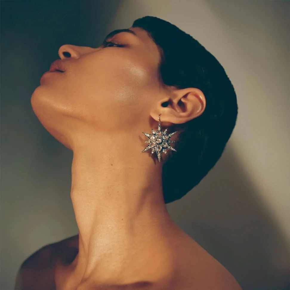 Antique diamond star earrings, circa 1870, worn in a dramatic portrait and available through Barron London.