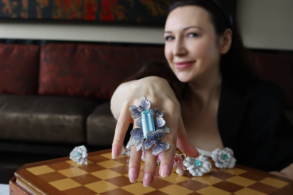 <p>A unique elongated emerald-cut aquamarine set into a floral ring with diamonds and sapphires by Narcisa Pheres</p>