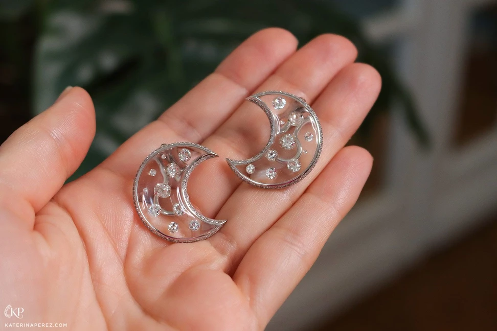 <p>Katerina Perez holding diamond and resin half moon earrings</p>