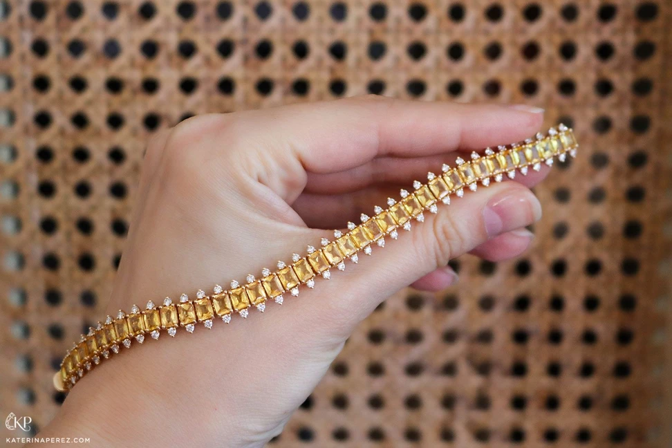 <p>Katerina Perez holding diamond and yellow sapphire bracelet</p>