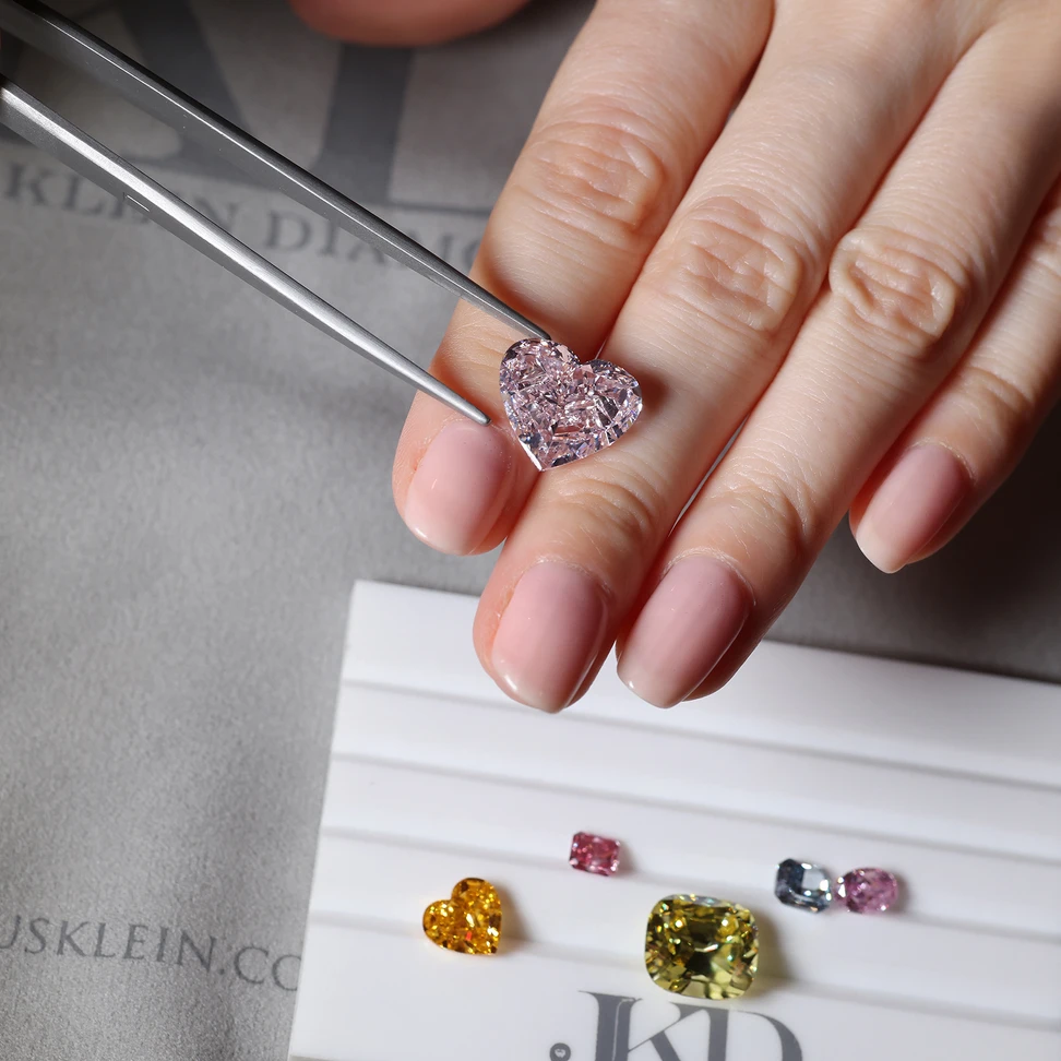 <p>A selection of natural Fancy coloured pink, blue, red, orange and yellow diamonds in various cuts and carat weights</p>
