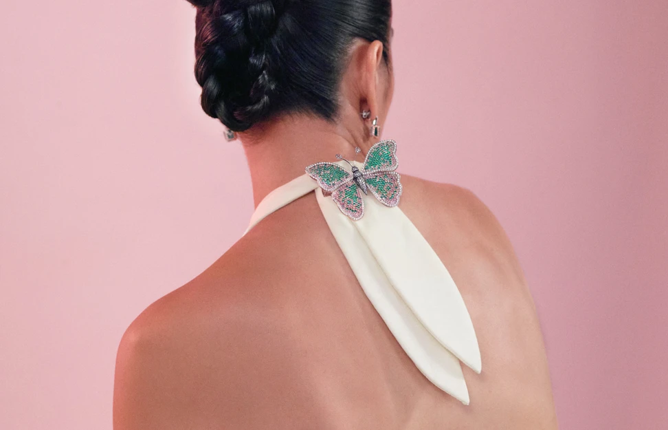 <p>Model wearing Muzo Emerald Colombia Mariposa brooch in gold, platinum, Muzo Emerald, Argyle pink diamonds, blue diamonds, violet diamonds and white diamonds from the Green Jewel Tradition</p>