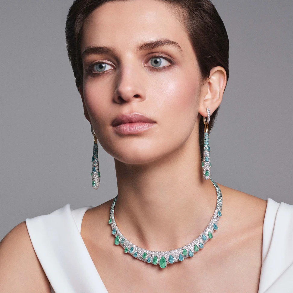 A model wears Pomellato Stile Libero Drops of Parabia earrings in rose gold with 14 pear-cut Paraiba tourmalines, 310 Paraiba tourmalines and 636 diamonds and Drops of Paraiba necklace in rose gold with 21 pear-cut Paraiba tourmalines, 579 Paraiba tourmalines and 1,092 diamonds