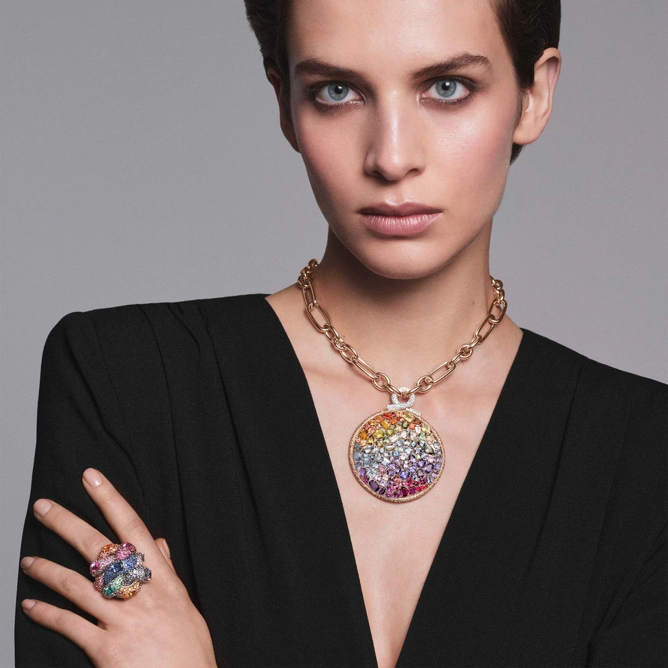 A model wears Pomellato Stile Libero Mandala Chromia necklace in rose gold with 99 fancy-cut multicolor sapphires, 528 brown diamonds and 231 white diamonds and Intreccio ring in rose gold with 8 fancy-cut multicolor sapphires, 1 pear-cut ruby, 675 purple, pink, orange treated, blue, light blue, lavender, pastel and grey sapphires and 83 rubies