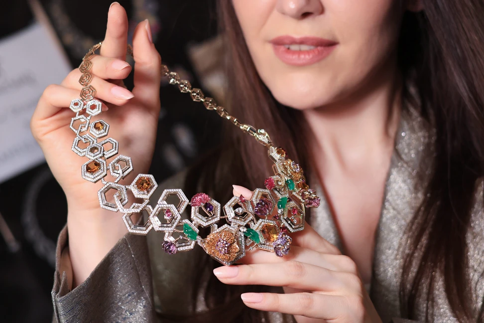Hand-carved gemstone blooms and leaves in pink tourmaline and amethyst unfold across the silhouette of this high jewellery necklace by Rahul Mishra
