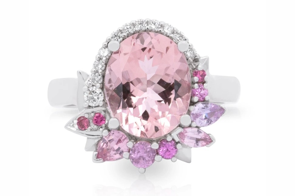 Artisans Bespoke Jewellers Sakura ring with an oval-shaped morganite and an asymmetrical halo of spinel, sapphire and diamonds set in 9k white gold 