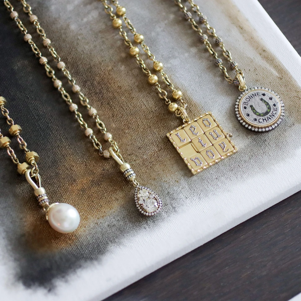 <p>A selection of new Sylva &amp; Cie pendants, including Neo Clasp pearl and diamond designs and a playful pendant with moving gold squares that spell out “love you”</p>
