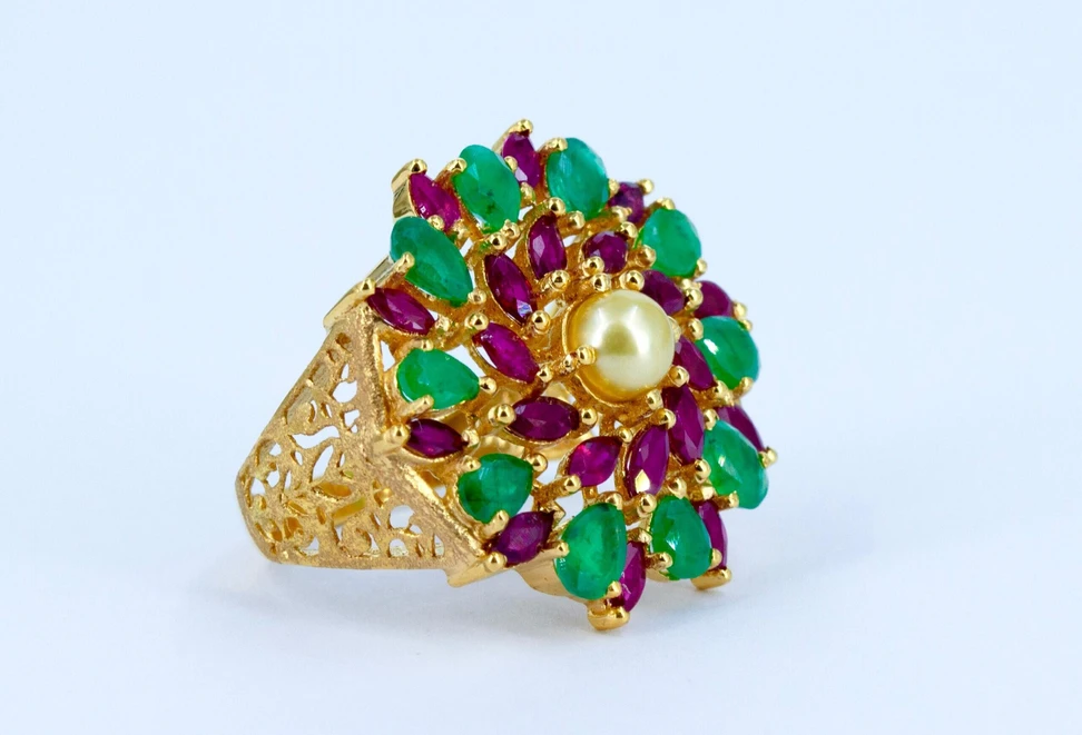 <p>Pearl Biography ring in 21k gold with a natural Bahraini pearl, marquise-cut rubies, and emeralds </p>
