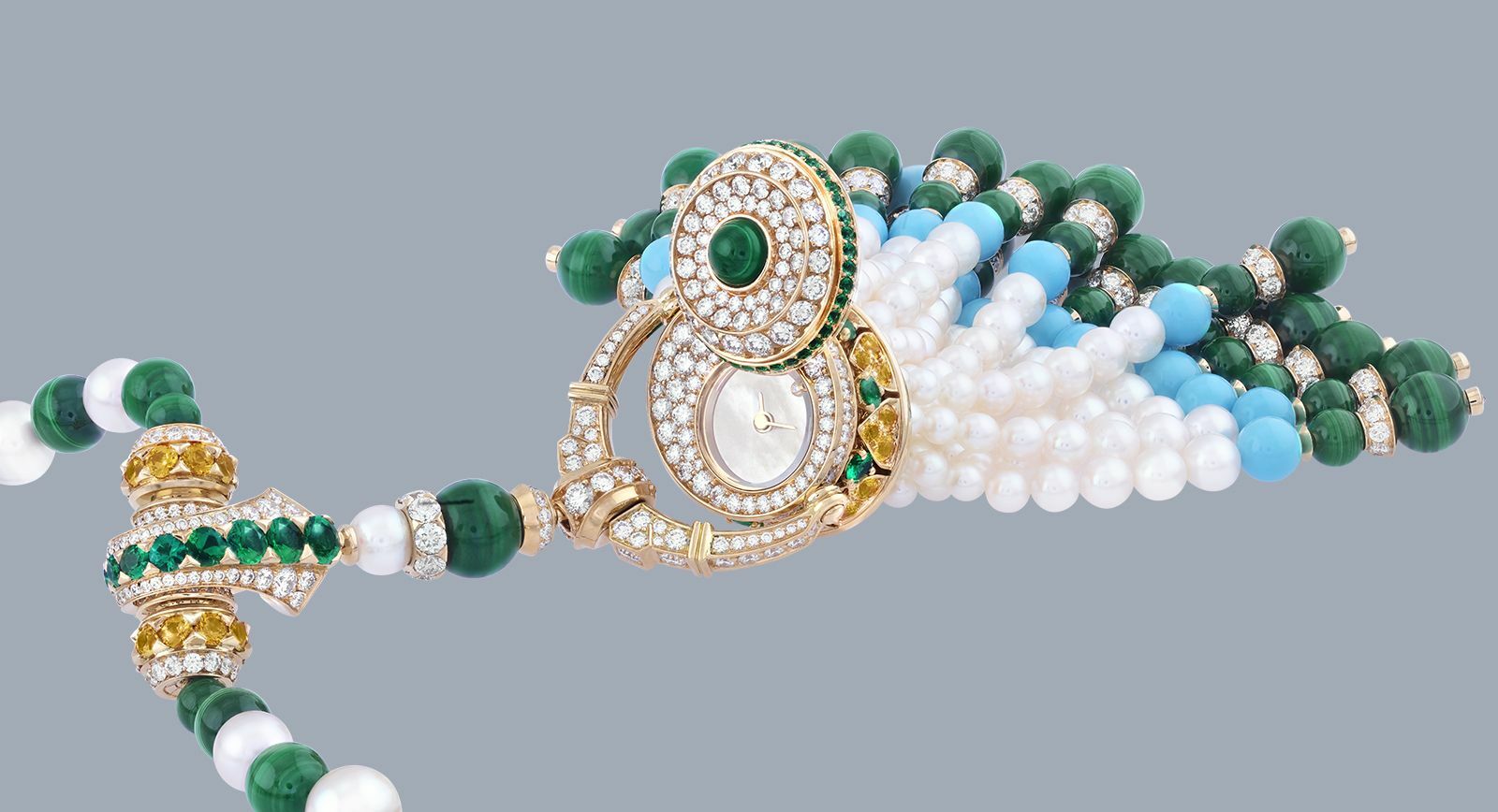 Van Cleef & Arpels Pompon Gaia transformable long necklace watch in yellow gold with yellow sapphires, emeralds, malachite, turquoise, white cultured pearls, white mother-of-pearl, diamonds and a quartz movement.
