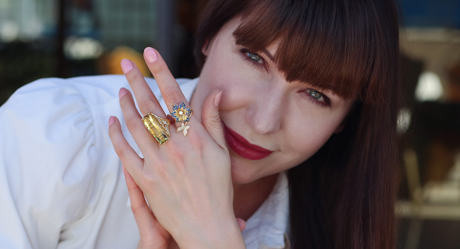 Katerina Perez wears rings by Lisa Nik, including (middle finger) a 20.30 carat golden beryl and diamond ring in 18k yellow gold from the Colors collection and the Butterfly Flower Bypass ring from the Rainbow collection with 1.6 carats of yellow and blue sapphires, also in 18k yellow gold 