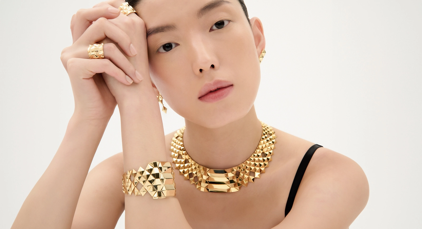 Model wears CADAR necklace, bracelet and rings in 18k textured yellow gold, from the Python collection