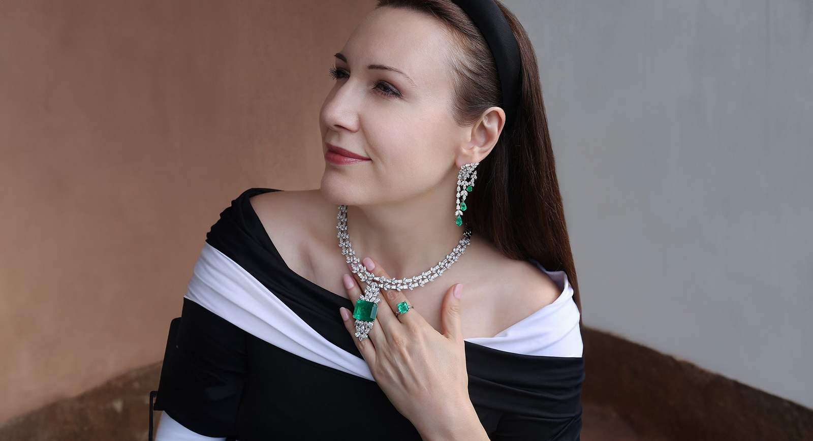 Katerina Perez wears the Emerald Luminaire earrings, Green Royale necklace and the Enchanted Emerald ring by Hassanzadeh Jewellery