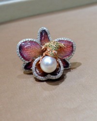 Cocktail ring with a rose gold frog sitting on a dried orchid covered in resin and holding a fresh water pearl by Francs V