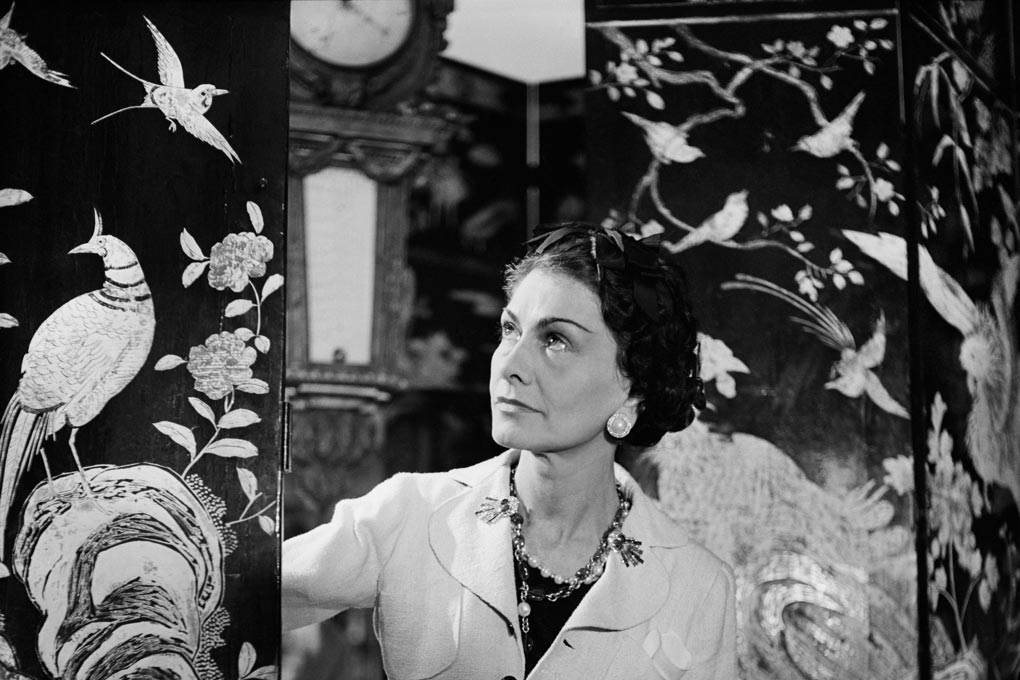 Gabrielle 'Coco' Chanel in her Rue Cambon apartment, surrounded by coromandel decorated screens