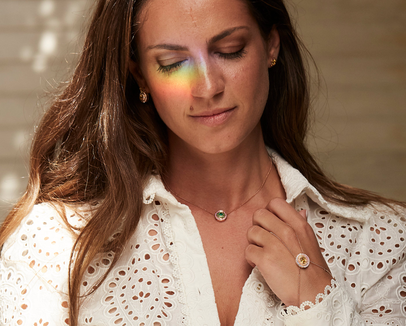 Alice Van Cal wearing her 'Alice Sphere' earrings with yellow sapphires and diamonds, pendant with emerald and diamonds, and the 'Alice Eclipse' hand jewel with central 1.15ct yellow sapphire and multi-coloured sapphires, all in 18k rose or yellow gold