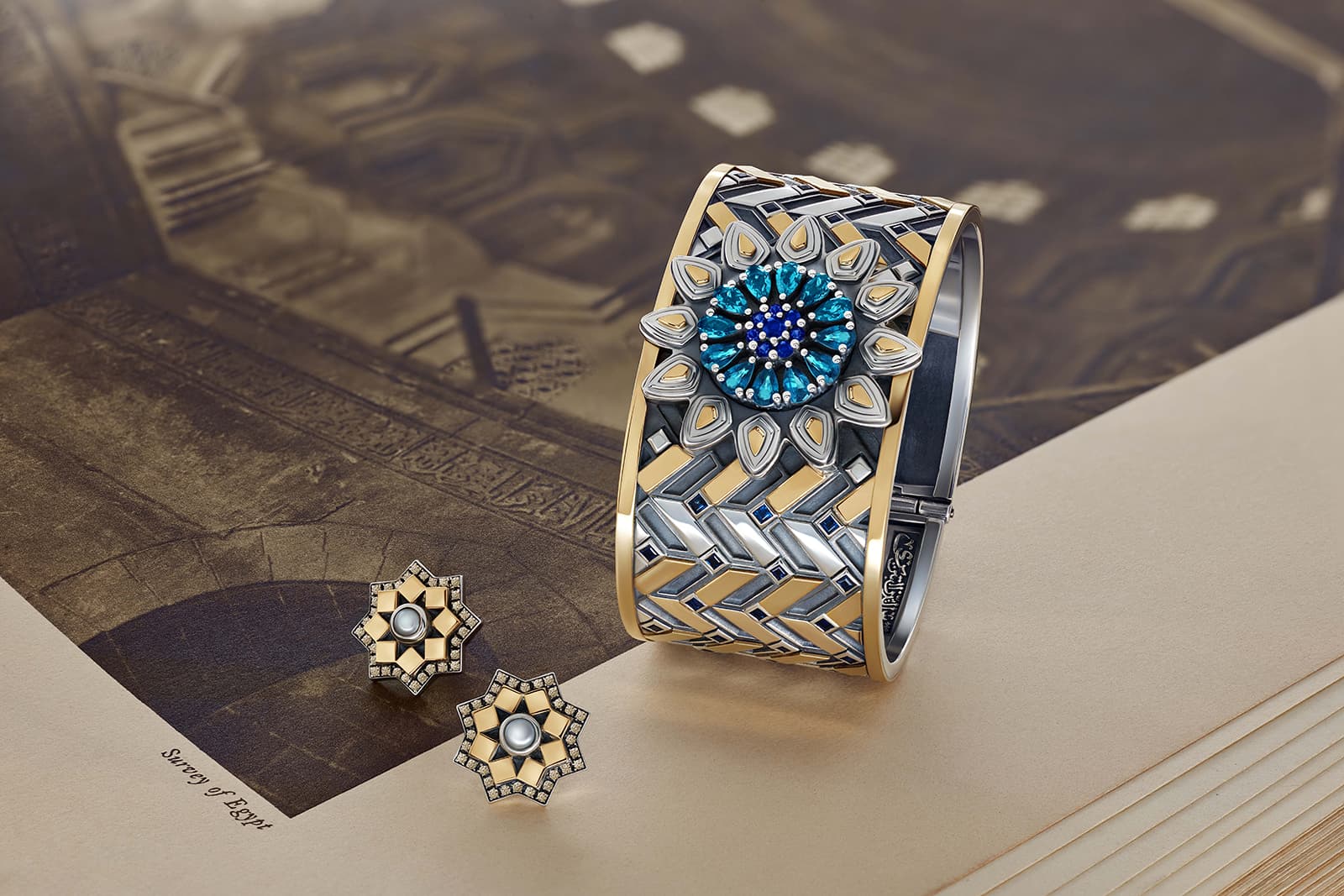 Azza Fahmy 'Mamluk' collection 'Qalawun Muzhir' cuff with sapphires and topaz and ‘Qalawun’ earrings with diamonds and pearls, both in yellow gold and sterling silver