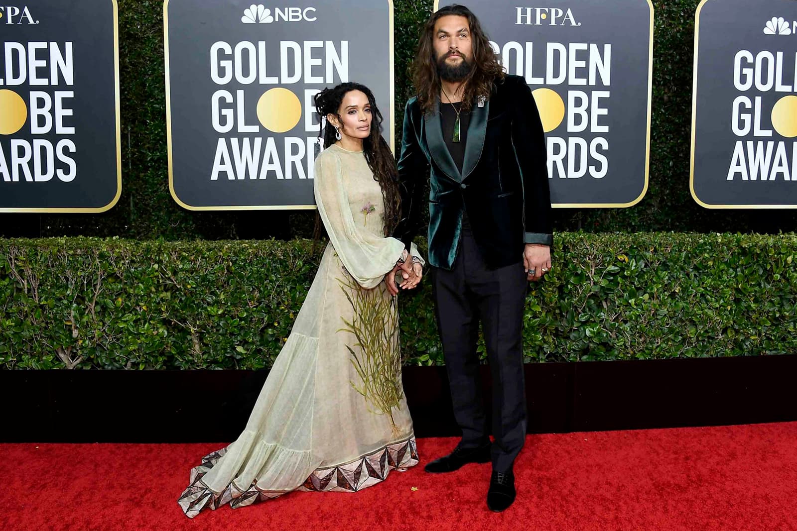 Lisa Bonet wearing Fernando Jorge chalcedony and diamond earrings, and her husband Jason Momoa wearing a Cartier Art Deco style brooch with onyx, emerald and diamonds in white gold, and 46mm Ballon Bleu de Cartier watch in rose gold, as well as his own jade pendant and rings