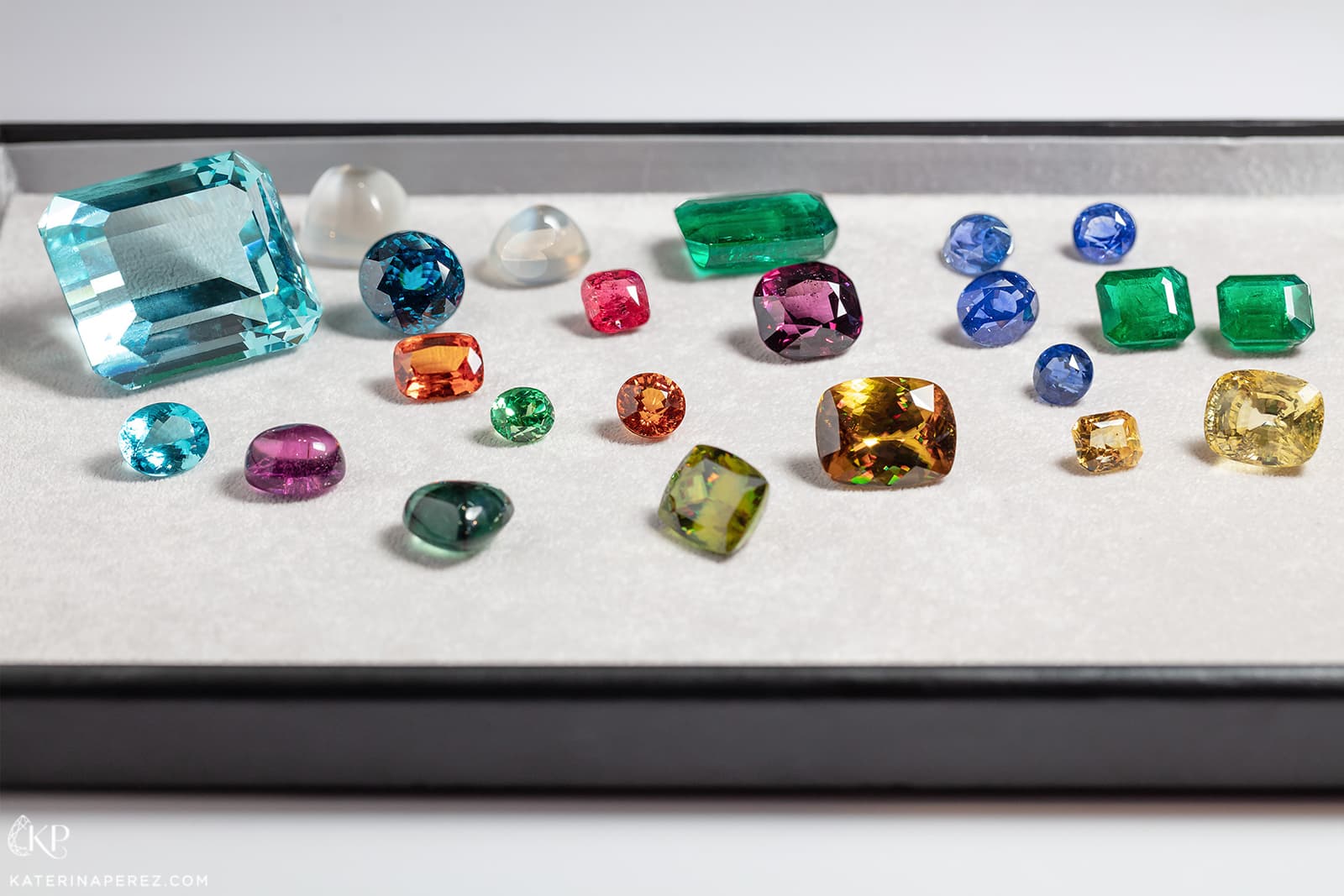 P&P Gems selection of gemstones including 450 cts Brazilian aquamarine, Paraiba tourmalines, emeralds, sphenes, spessartite garnets, moonstone and spinels. Photo by Simon Martner
