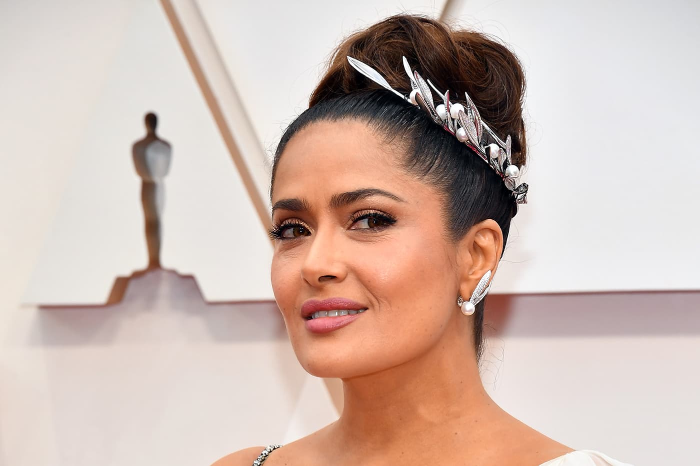 Salma Hayek wearing Boucheron Feuilles de Laurier necklace as headpiece and earrings, both with diamonds and pearls in white gold