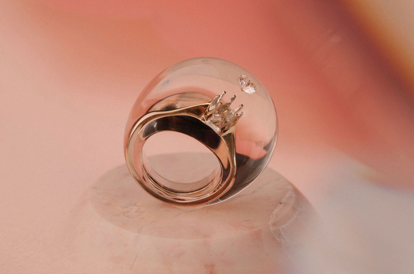 Изделие Ами Масамитсу – это восстановленное помолвочное кольцо из 18-каратного золота и одного ограненного бриллианта, заключенного в прозрачный акрил