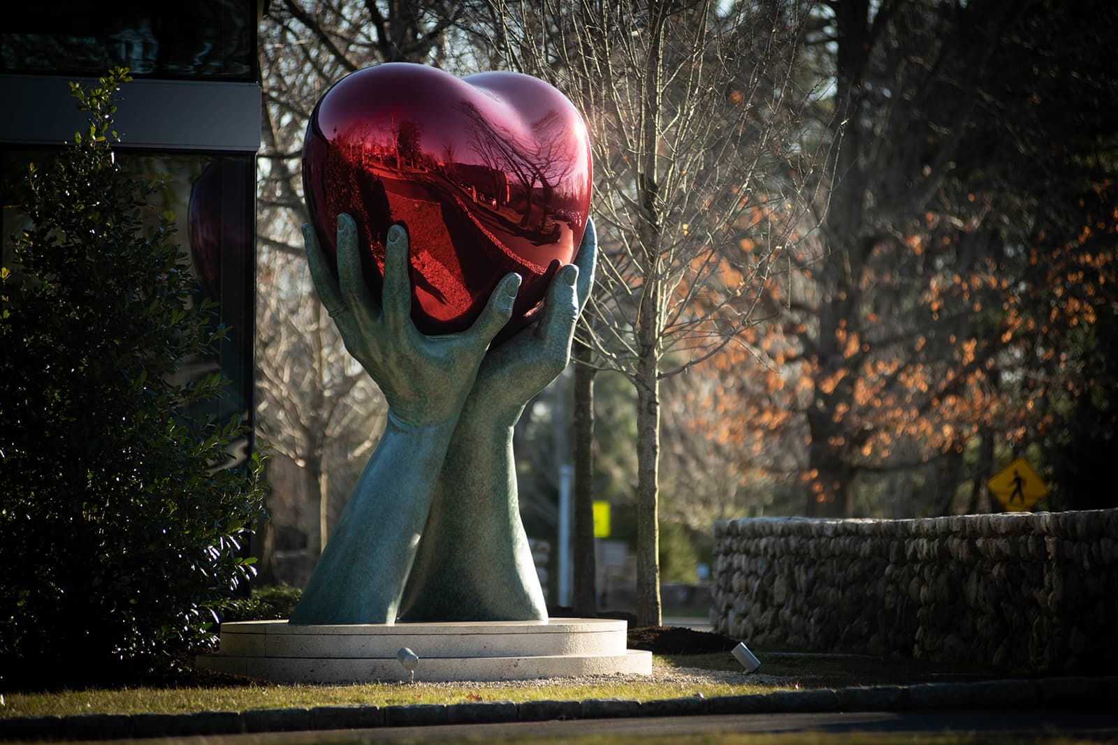 A bronze and stainless steel sculpture by Lorenzo Quinn titled 'Give from the Heart'