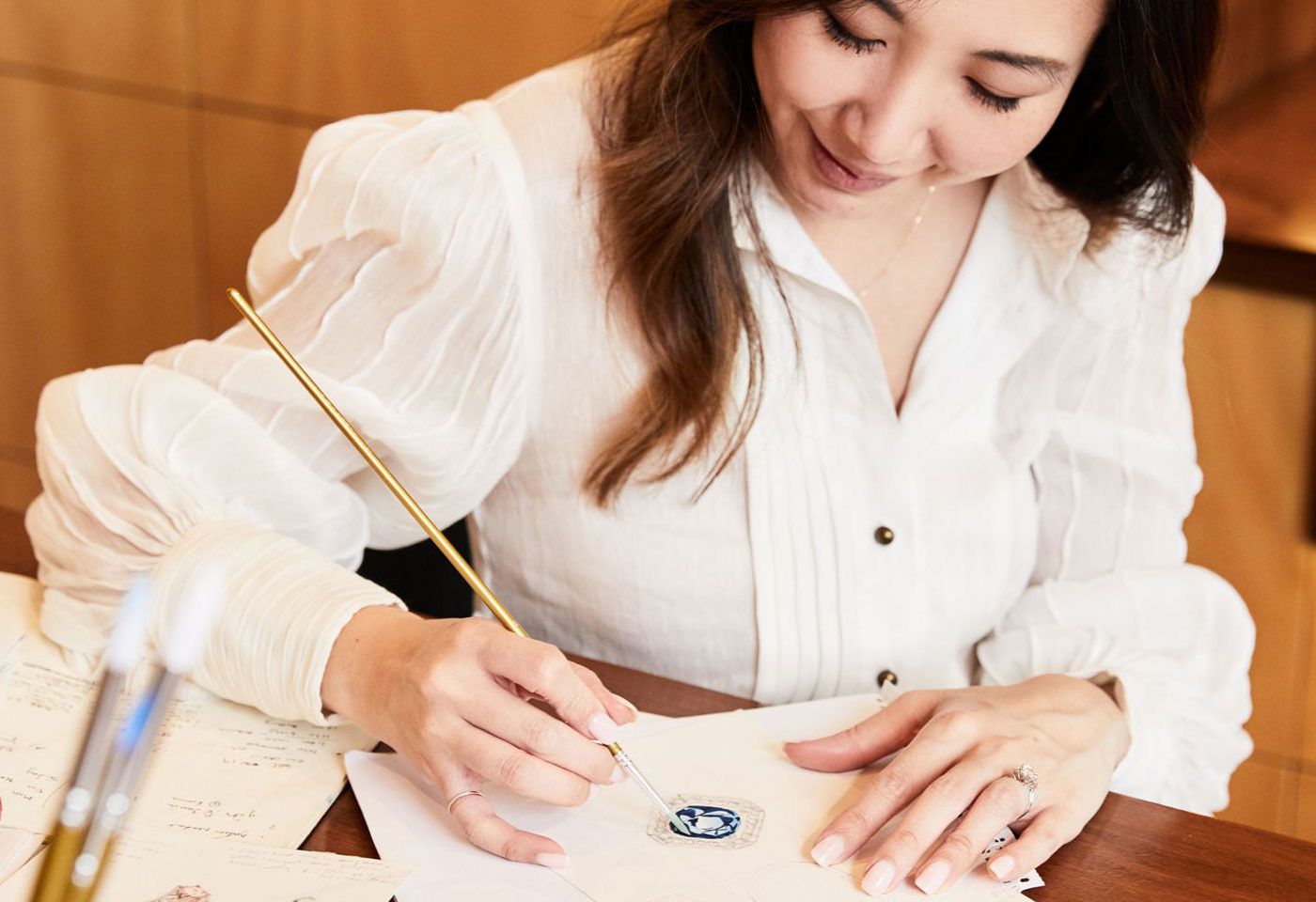 Faith Hilda of Faith Jewels hand-painting a jewellery design for a bespoke client