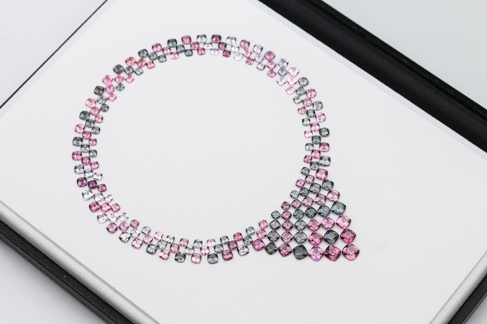 A necklace layout with multiple shades of cushion-shaped spinel gemstones by Paul Wild
