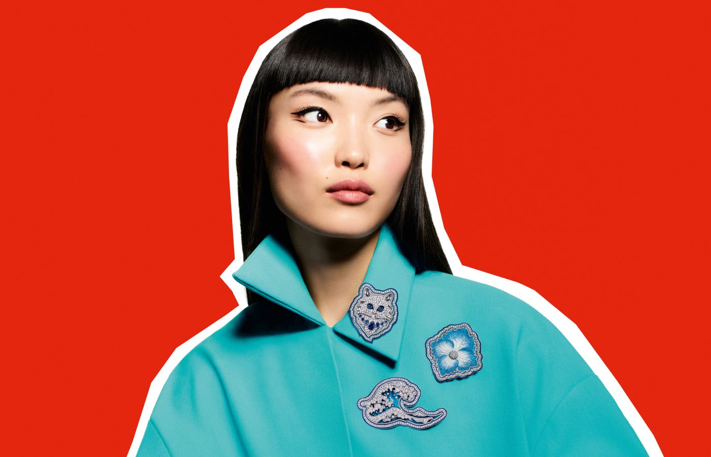 A model wears a trio of Boucheron Do Not Iron! brooches, including Wladimir the Cat, the Hokusai Wave, and a blue Hydrangea flower from the More is More High Jewellery collection  