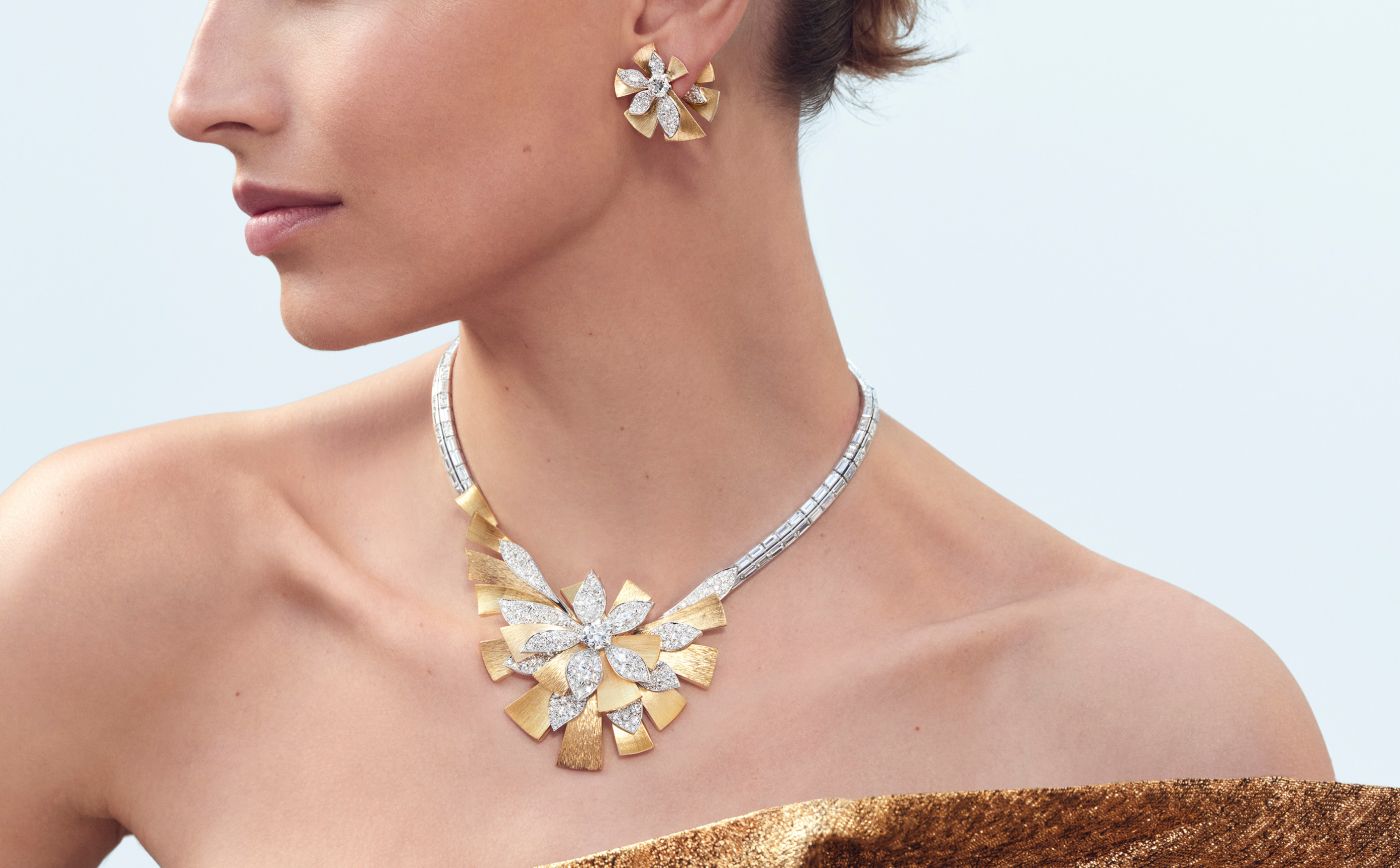 Model wearing Chaumet Magnolia earrings and necklace in gold, white gold and diamond from Le Jardin de Chaumet High Jewellery collection 