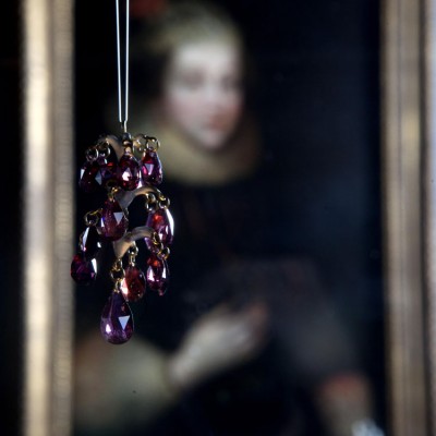 A garnet pendant hanging in front of a portrait of Elizabeth Wriothesley, Countess of Southampton