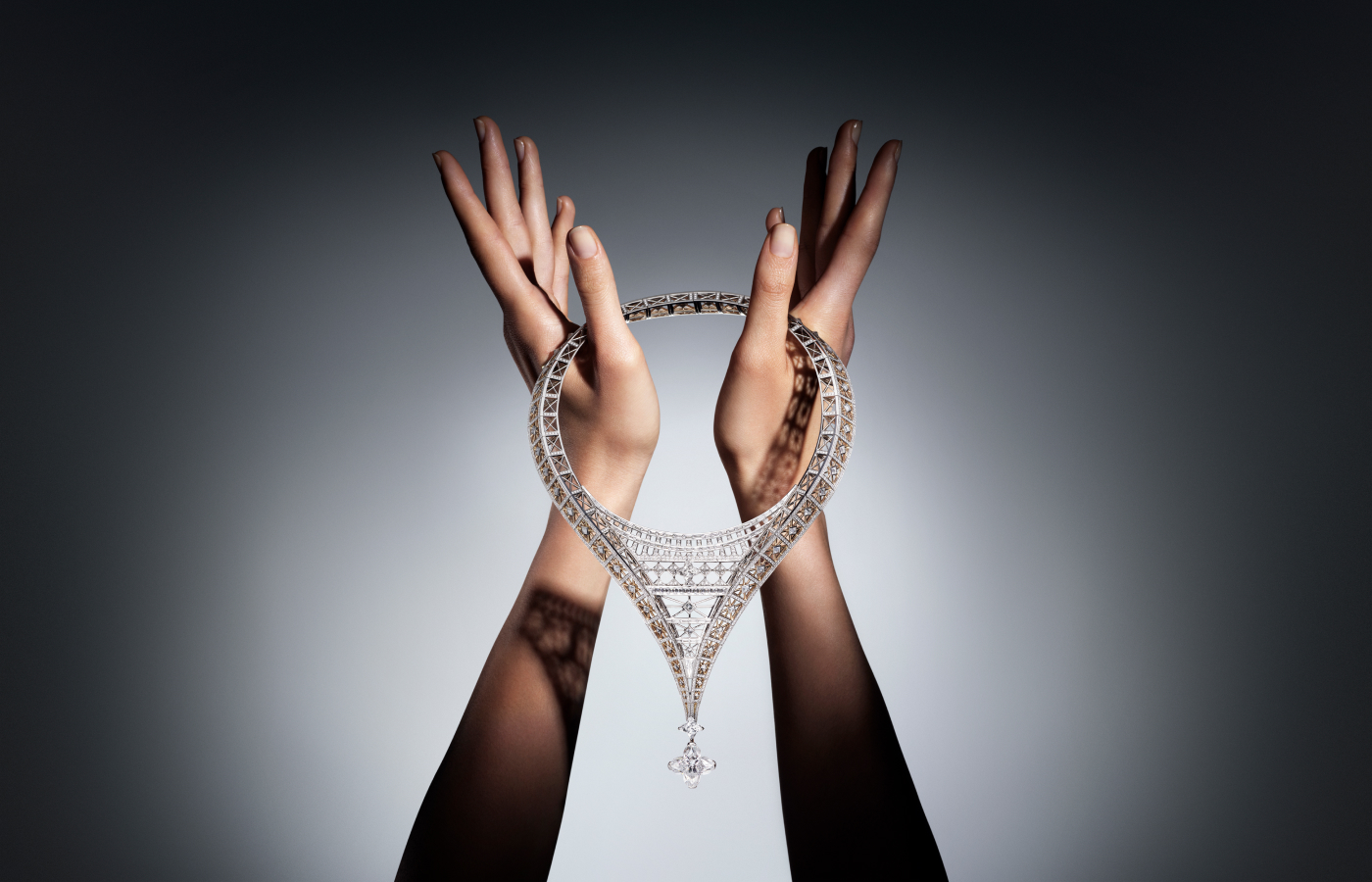 Model holding the Louis Vuitton Victoire transformable necklace with one 15.16 - carat LV Monogram Flower cut diamond, two LV Monogram Star cut diamonds of 3.06 and 2.53 - carats each and diamonds in platinum and gold from the Awakened Hands, Awakened Minds collection