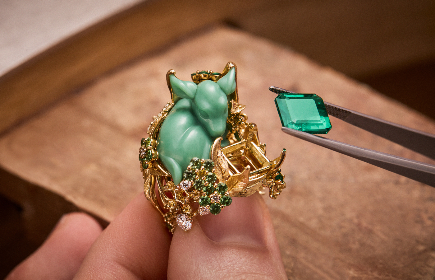 Adding a large Colombian emerald to the Diorama Forêt Enchantée ring featuring a ‘sleeping’ glyptic chrysoprase fawn along with diamonds, emeralds and tsavorite garnets, set in engraved 18k yellow gold, part of the Diorama Forêt Enchantée set from the Diorama & Diorigami High Jewellery Collection