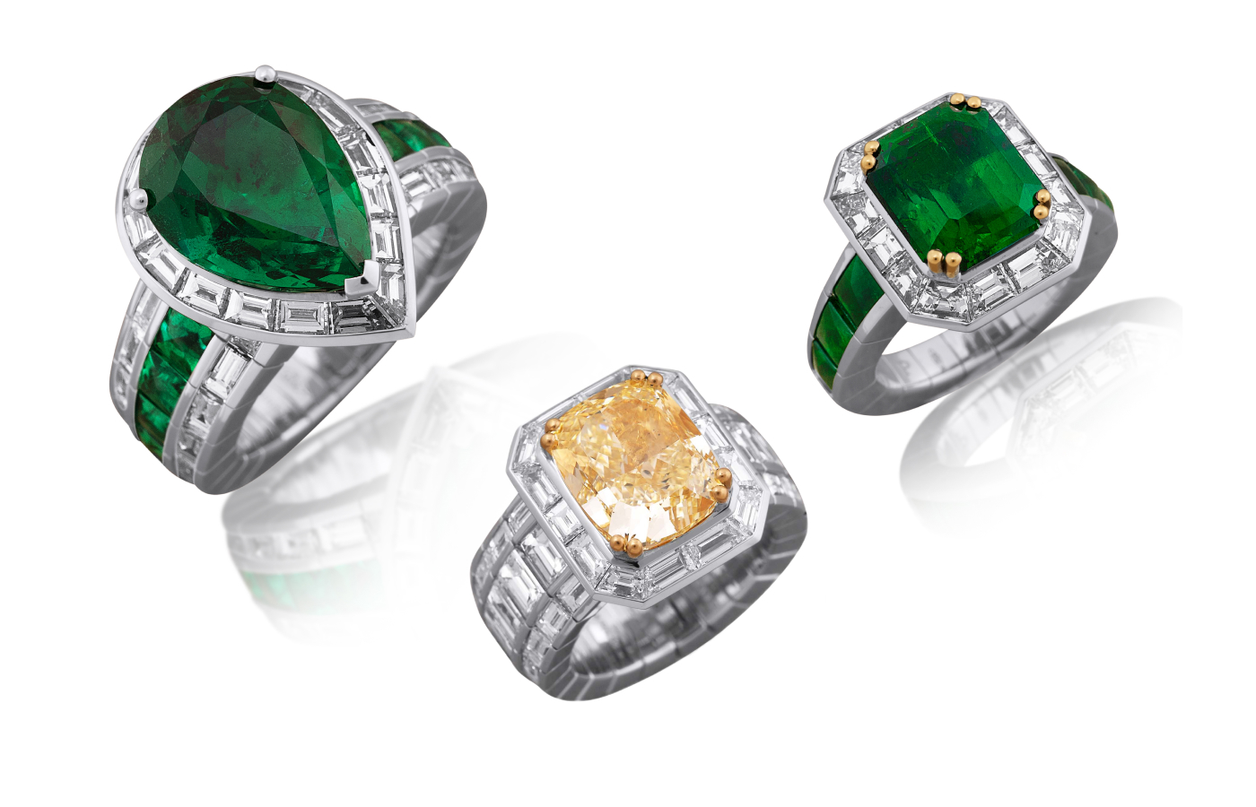 A trio of Picchiotti rings set with (from left to right) a 6.11 carat pear-shaped Zambian emerald, a natural fancy yellow radiant-cut diamond of 7.13 carats, and a 5.41 carat octagonal Colombian emerald