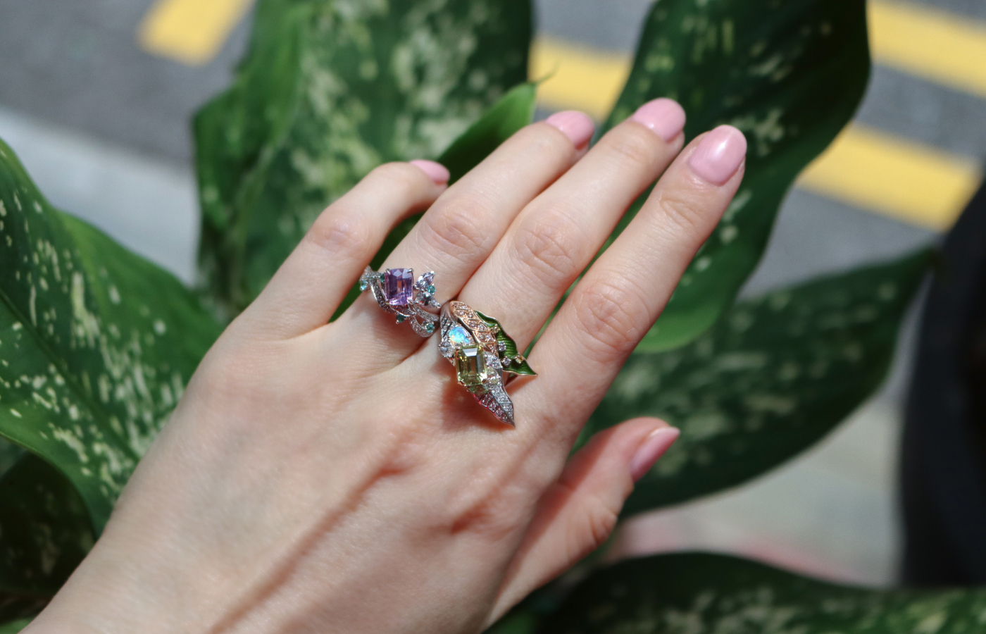 Katerina Perez wears the MADLY Floral ring (left) with a 2.10 carat cushion-cut pink sapphire, a marquise-shaped purple spinel, pastel pear-shaped sapphire, Paraiba tourmaline and diamond, alongside the ‘Leaf Me Alone’ ring with a step-cut 2.13-carat chrysoberyl, yellow sapphire, green garnet, black opal, and diamonds, both in 18k gold 