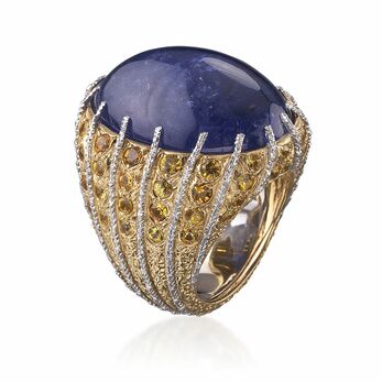 Cocktail ring with purplish-blue tanzanite on a mounting with white gold sprigs alternating with yellow gold and diamonds